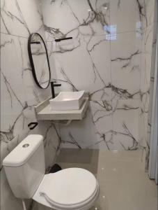 un bagno con un water bianco e un lavandino di casa charmosa serra da capivara a Coronel José Diaz Altre 9 foto