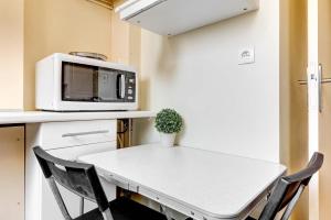 une petite cuisine avec une table et un micro-ondes dans l'établissement Studio Rue Nationale, à Paris 5 autres photos