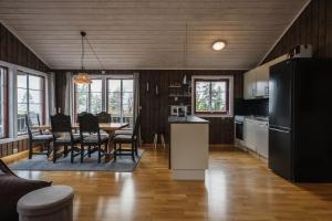 a kitchen and dining room with a black refrigerator at Fulufjellet cabins in Ljørdalen