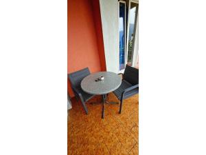 a small table and two chairs on a balcony at Apartment with two rooms and shared bathroom in Minusio