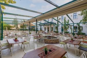 an outdoor patio with tables and chairs and a fountain at Garni Hotel Zavicaj in Belgrade +20 photos