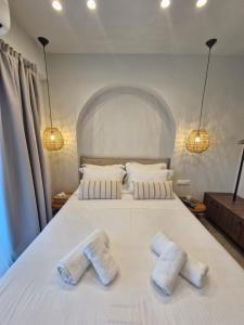 a bedroom with a white bed with two towels on it at Blue Dream - Beach Front Villa in Kastrí