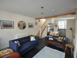 a living room with a blue couch and leather chairs at Cornerstones in Ambleside