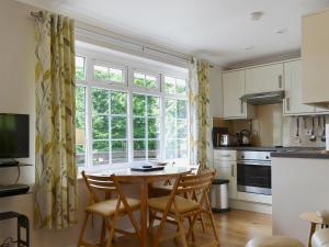 Una cocina con mesa y sillas y una ventana. en Gone Sailing, en Windermere
