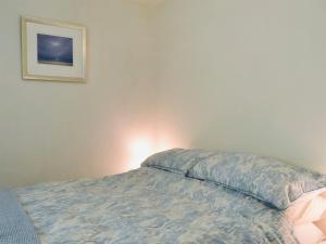 Una cama en un dormitorio con un cuadro en la pared. en Gone Sailing, en Windermere
