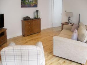 un salon avec un canapé et une télévision dans l'établissement Bluebell Cottage, à Nether Stowey