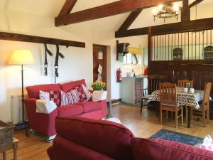 a living room with red couches and a table at The Coach House - 15661 in Tytherton Lucas