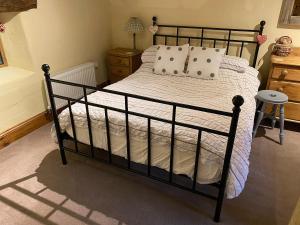 a bedroom with a black bed with white sheets and pillows at Finkle Barn in Fryup