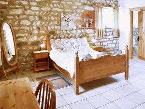 a bedroom with a bed and a stone wall at Guillemot Cottage in Flamborough