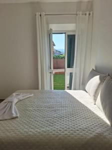 a bedroom with a white bed with an open window at DGD house in Carrara +69 photos