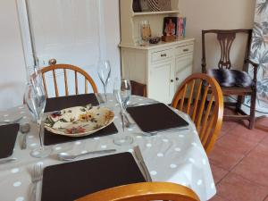 a dining room table with a plate of food and wine glasses at Squirrel Cottage in Thornton Dale