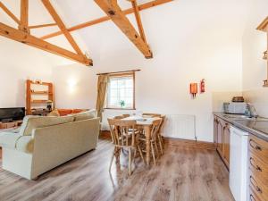 a kitchen and living room with a couch and a table at Leedale Cottage in Saltmarshe