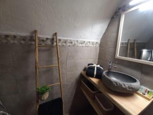 ein Badezimmer mit Waschbecken und Spiegel in der Unterkunft La Taverne de papy in Saint-Crépin