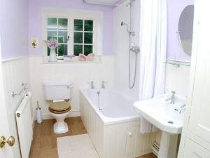 ein weißes Badezimmer mit Toilette und Waschbecken in der Unterkunft Applewood Cottage in Loders