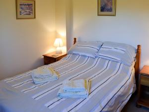 a bedroom with a large bed with towels on it at Carters Cottage in Puncknowle