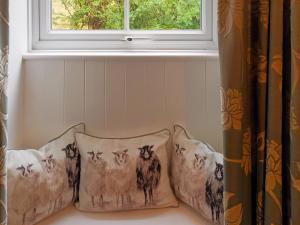 a couple of pillows sitting under a window at Honeymead Cottage in Wick