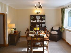 a dining room with a table and a couch at Rose Cottage in Cold Ashton
