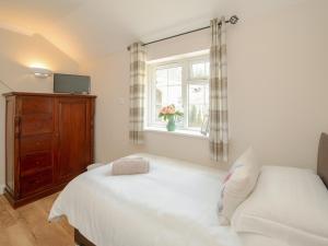a bedroom with a white bed and a window at 1 Luckington Stables-W8321 in Holcombe +10 photos