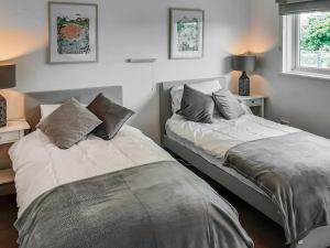 two beds sitting next to each other in a bedroom at Valley Truckle Bungalow in Camelford +5 photos