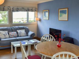 a living room with a table and a couch at Treyarnon in St Merryn