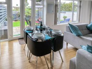 a dining room with a table and a couch at Palm Villa in Saint Columb Minor