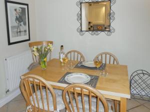 a dining room table with chairs and a mirror at Bellagio in Padstow