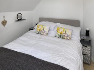 a bed with white sheets and pillows on it at Bellagio in Padstow
