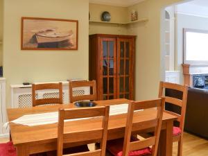 a dining room with a wooden table and chairs at Sandpipers in Padstow