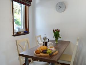 ein Holztisch mit einem Teller mit Essen darauf in der Unterkunft 15 Cairnbaan Cottage in Cairnbaan