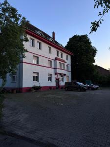 Un gran edificio blanco con coches aparcados en un estacionamiento. en DUK42a, en Karlsruhe