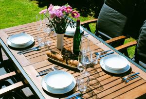 a wooden table with plates and glasses and a bottle of wine at Nr 19 - Ferienhaus "Florentina" in Carolinensiel