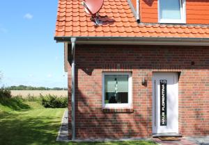 a brick house with a window with a dog in it at Nr 19 - Ferienhaus "Florentina" in Carolinensiel