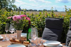 a table with glasses and a bottle of wine and flowers at Nr 19 - Ferienhaus "Florentina" in Carolinensiel +28 photos