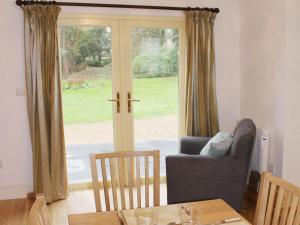 sala de estar con silla, sofá y ventana en Bodwen Corner Cottage, en Wootton Bridge