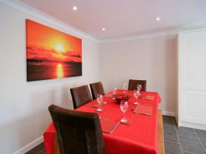 a dining room with a red table and chairs at Beach Retreat - E5558 in Mundesley