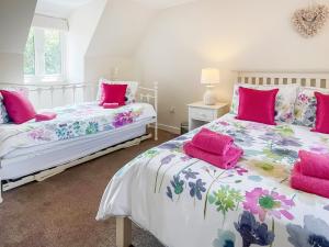two beds in a room with pink pillows at Beach Retreat - E5558 in Mundesley