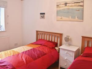 een slaapkamer met 2 bedden en een foto van een strand bij Oak Cottage in Woolfardisworthy