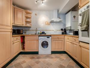 a kitchen with a washing machine in the middle at Tennay Cottage in Wareham