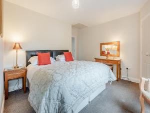 a bedroom with a large bed with red pillows at Stackgarth in Gilcrux +18 photos