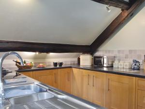 a kitchen with wooden cabinets and a sink at The Mill in Mungrisdale