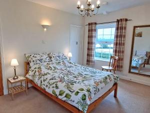 una camera da letto con un letto e uno specchio di Foston Grange Cottage a Bulmer Altre 7 foto