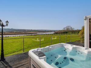 un bain à remous sur une terrasse avec vue sur un champ dans l'établissement Y Dorlan, à Cardigan