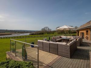 une terrasse avec un canapé et un parasol dans l'établissement Y Dorlan, à Cardigan