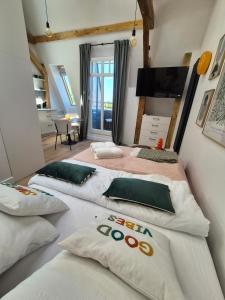 a bedroom with two beds and a flat screen tv at Between the roofs of Jeżyce in Poznań