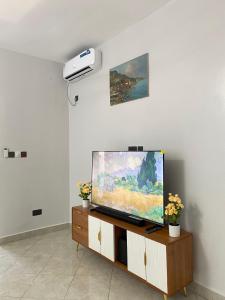 a flat screen tv sitting on a stand in a room at Fantasea Villa in Ukunda Airport +25 photos