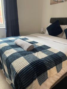 a bed with a blue and white blanket on it at Stylish 2Bedroom Flat - City Centre - Near Leeds Station in Leeds +8 photos