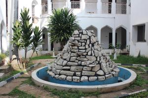 a rock fountain in front of a building at Halal Fountain Hotel Kaduna in Kaduna