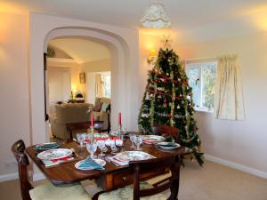 - une table avec un arbre de Noël dans le salon dans l'établissement Stable Cottage, à Lyminster