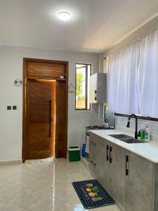 a kitchen with a sink and a wooden door at Fantasea Villa in Ukunda Airport