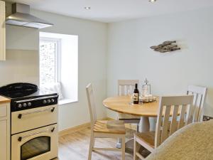 una cucina e una sala da pranzo con tavolo e piano cottura di River Cottage a Bladnoch